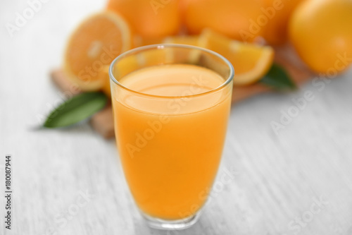 Glass of fresh orange juice on wooden table