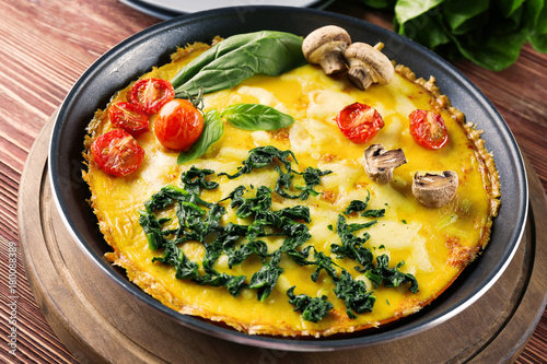 Tasty frittata with spinach on table
