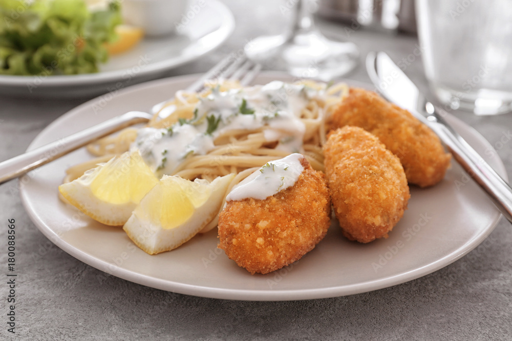 Plate with tasty salmon croquettes and spaghetti on table Plate with tasty salmon croquettes and spaghetti on table