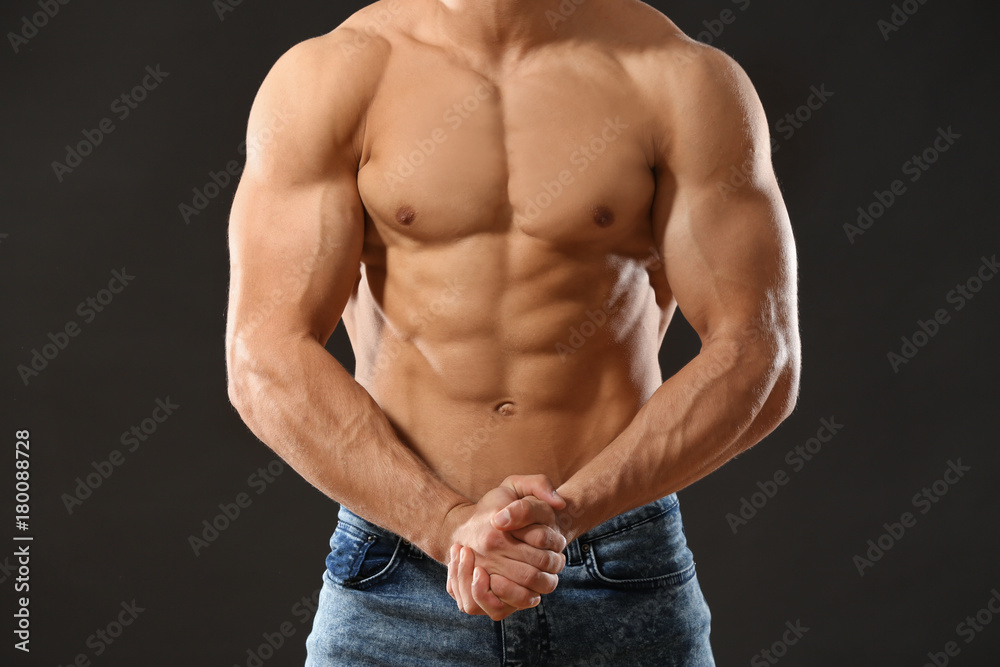 Muscular young man on black background