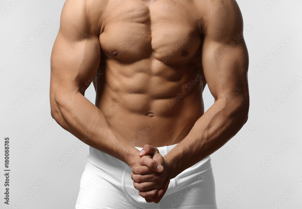 Fototapeta premium Muscular man in underwear on light background