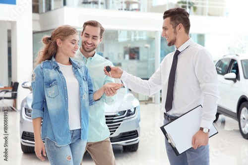 Car salesman giving key to ...