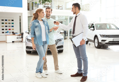 Car salesman giving key to ...