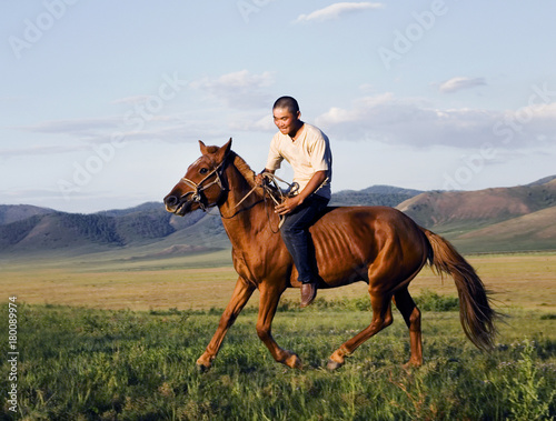 Young man riding a horse in a scenic view of nature.