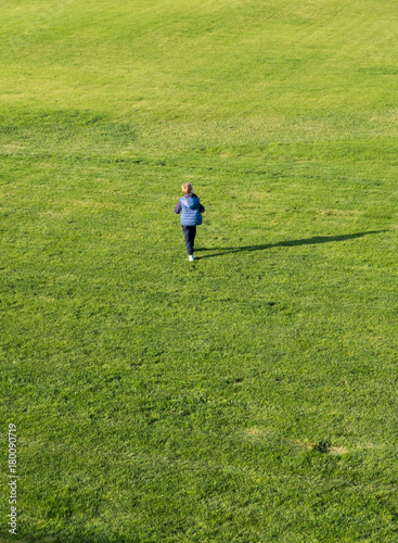 Small boy running on green grass outdoor