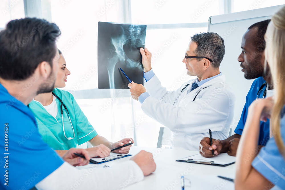 team of doctors looking at x-ray scan team of doctors looking at x-ray scan