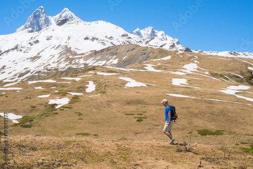 Traveler, with backpack, walks along mountain plateau