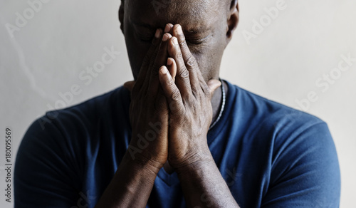 Foto Black man with hands covered his face feeling worried