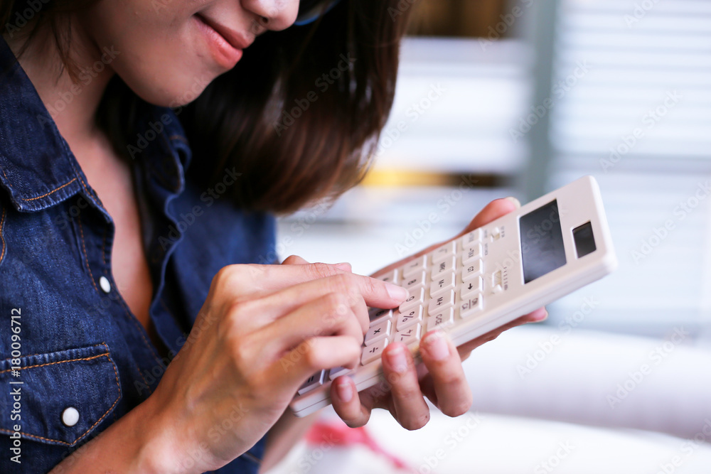Closeup business woman hand using a calculator Closeup business woman hand using a calculator