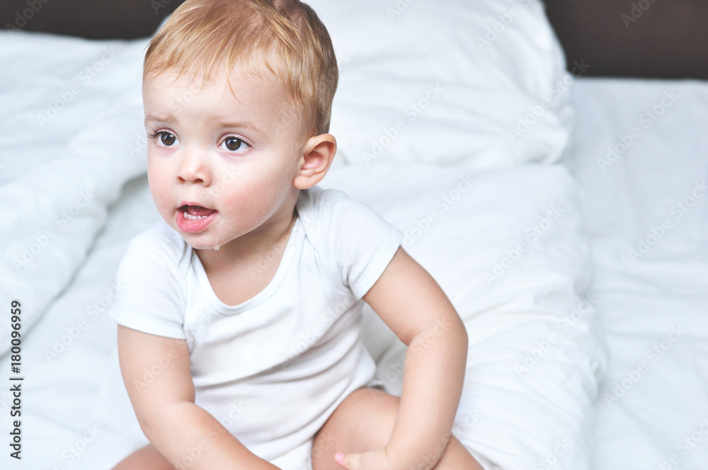 Little baby boy just woke up and is sitting on a white bed in a white bodysuit
Little baby boy just woke up and is sitting on a white bed in a white bodysuit