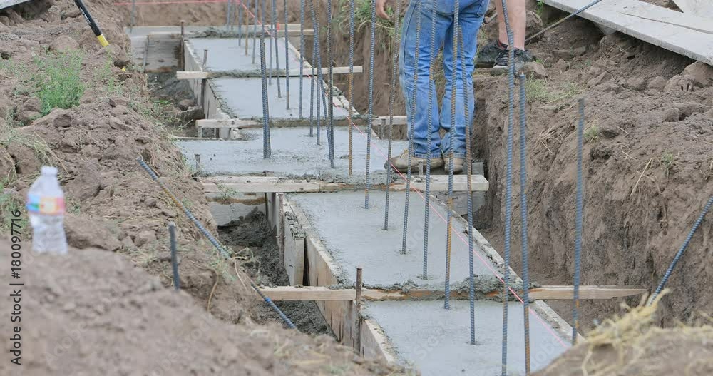 Construction concrete foundation for new building. Construction of rural farm agriculture building. Pouring concrete for footing and foundation. Engineering architectural design.