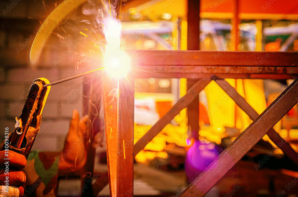 Workers welding steel structure to assemble parts of the steel structure.