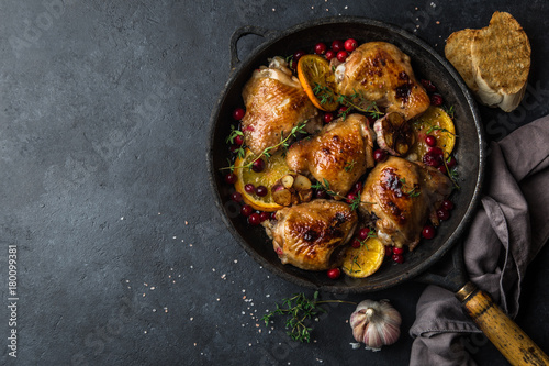 roasted  chicken with orange, cranberry and spicy herbs on pan photo