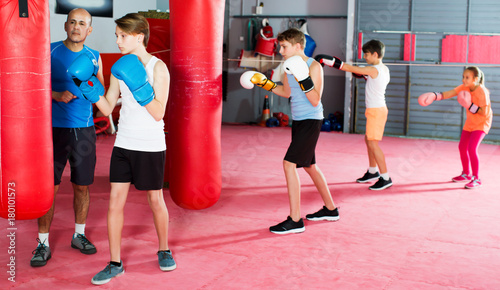 Boxing instructor and young children practicing blows