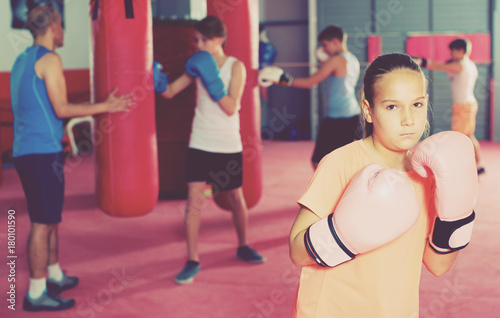 Girl with boxing gloves posing in defended stance