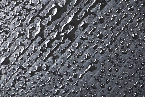 Abstract background of water droplets on black surface.