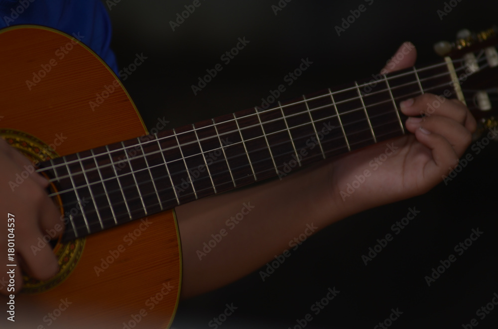 hand playing on acoustic guitar - soft focus with vintage filter