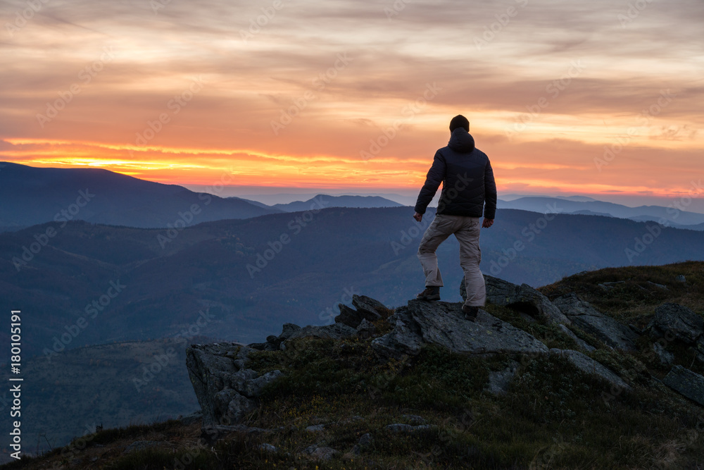 Hiker on mountain edge at scenic sunset