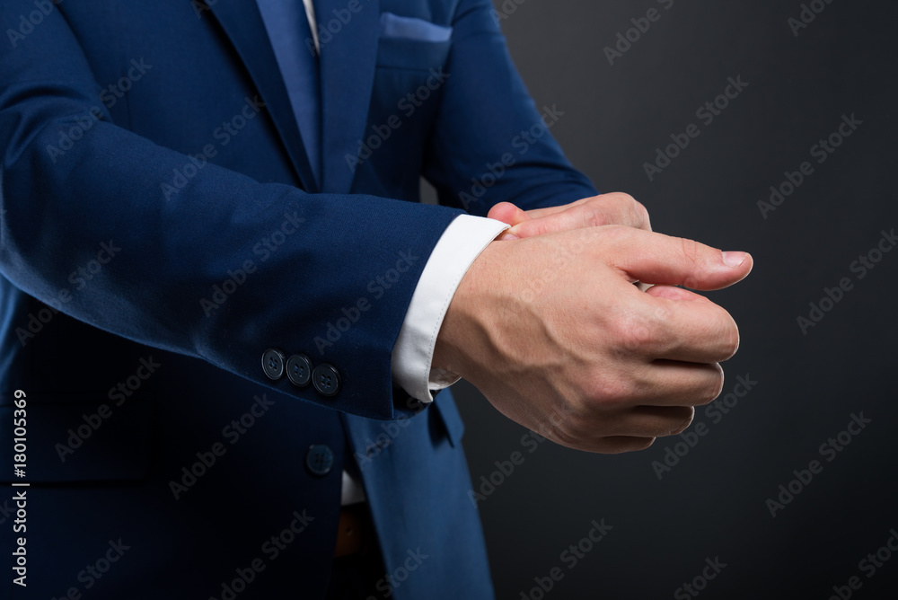 Closeup of elegant young man adjusting his sleeve