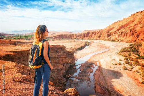 Young woman looking at beautiful landscape. Nature of Morocco view from above. Traveler girl stands on a rock looks up at the valley of Ounilla photo