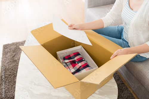 woman opening personal online shopping parcel