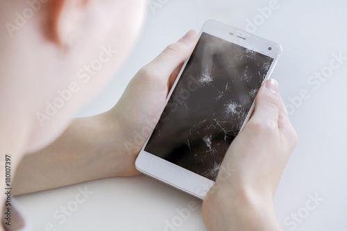 Crying girl with broken smart phone.