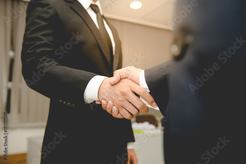 Asian Business people shaking hands, finishing up a meeting,mission complete photo