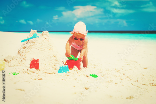 Fototapeta Naklejka Na Ścianę i Meble -  cute little girl play with sand on beach