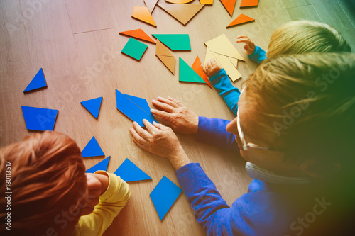 Foto teacher and kids playing with geometric shapes puzzle