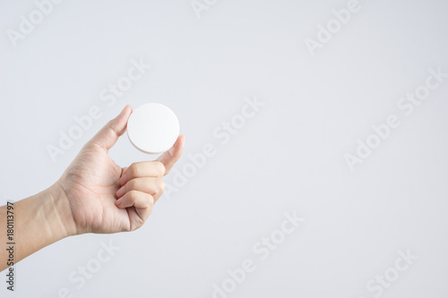Hand holding round face sponge for cosmetic