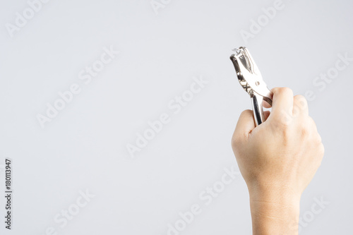 Hand holding silver paper punch one round hole for office work