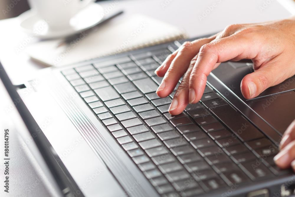 Woman working on a laptop. Close up woman hand holding computer laptop on wood desk Woman working on a laptop. Close up woman hand holding computer laptop on wood desk