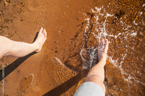 Splashing water with foot on sand beach