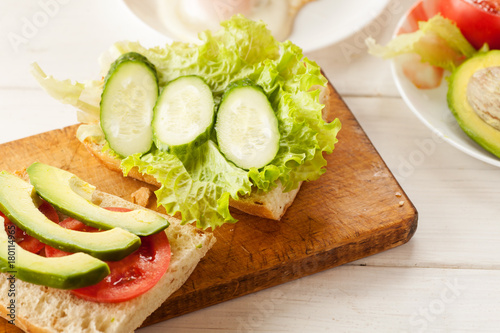 Sliced avocado, tomatoes, cucumber on a fresh ciabatta bread