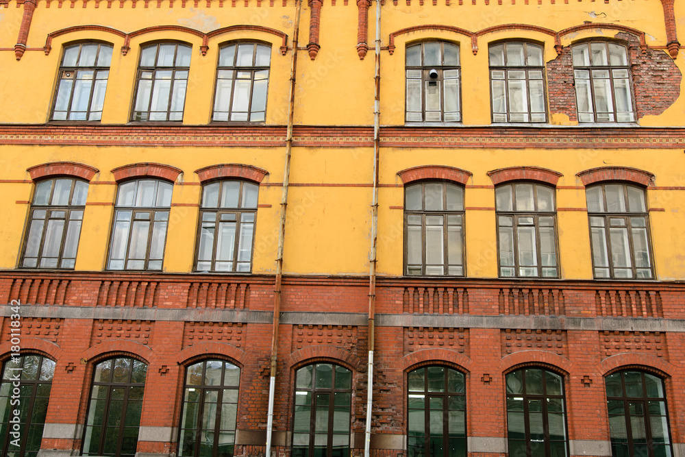 Facade of old yellow-red building in Vyborg, Russia