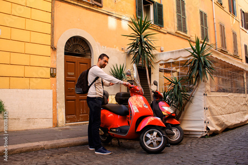 Man with red scooter is ready to drive scooter in  Rome  Italy
