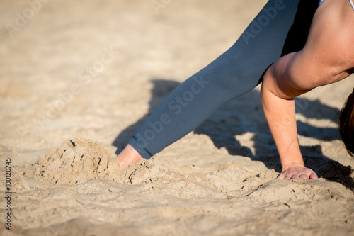 Woman practicing yoga in the sand - Extended Side Angle Pose — Utthita Parsvakonasana - Autumn day