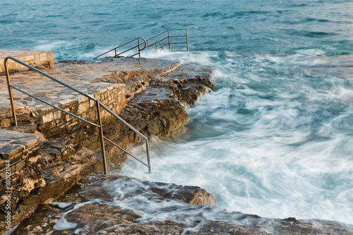 Swim ladder leading to stormy mystic sea