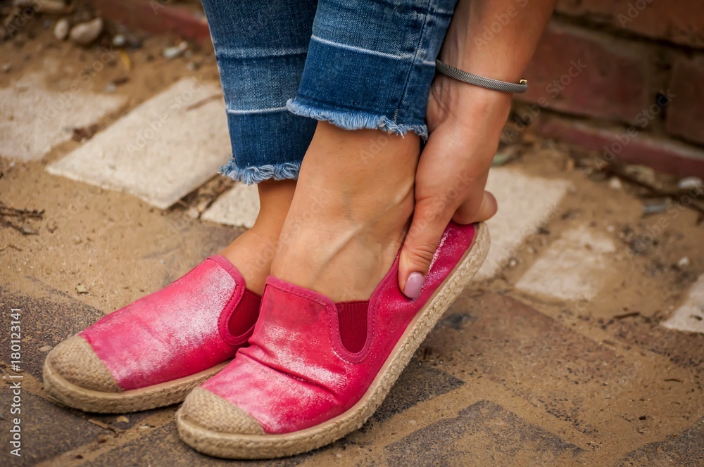 Young female touching her rubbed foot. New shoes cause sore skin on foot, rubbing foot blister problem, callus stock image. Young female touching her rubbed foot. New shoes cause sore skin on foot, rubbing foot blister problem, callus stock image.