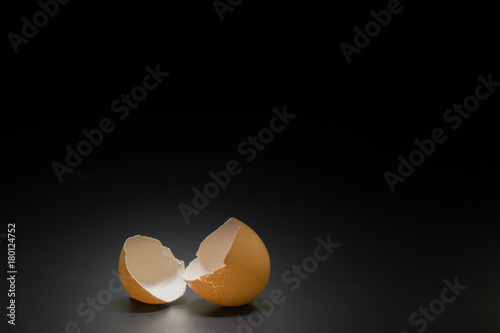 broken egg on black background and space for text on center of image