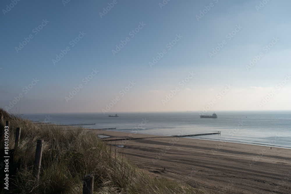 Beach with dunes at daytime. Beautiful dreamy shot of the endless sea in Zoutelande, Netherlands