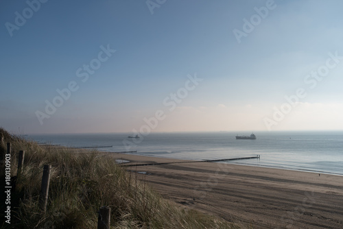 Beach with dunes at daytime. Beautiful dreamy shot of the endless sea in Zoutelande, Netherlands © Christophe