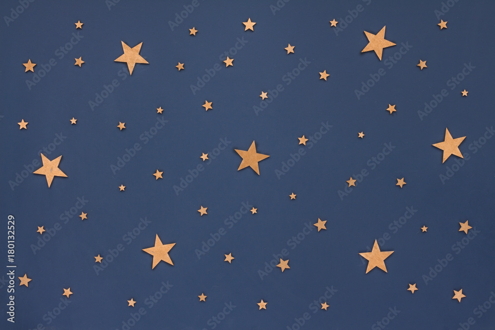 Christmas golden stars on dark blue background. Stars sky, flat lay, top view