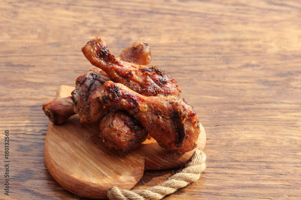 Grilled chicken legs on cutting board. Rustic dinner background Grilled chicken legs on cutting board. Rustic dinner background