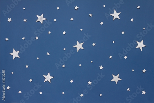 Christmas silver stars on dark blue background. Stars sky, flat lay, top view