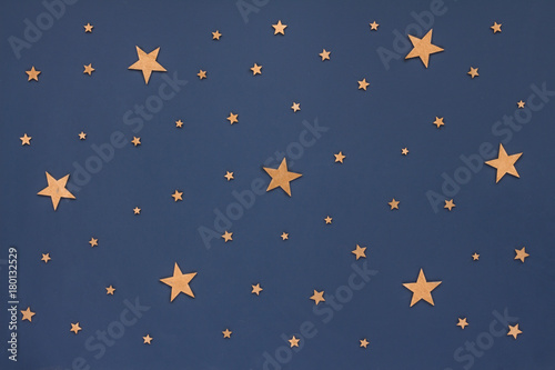 Christmas golden stars on dark blue background. Stars sky, flat lay, top view
