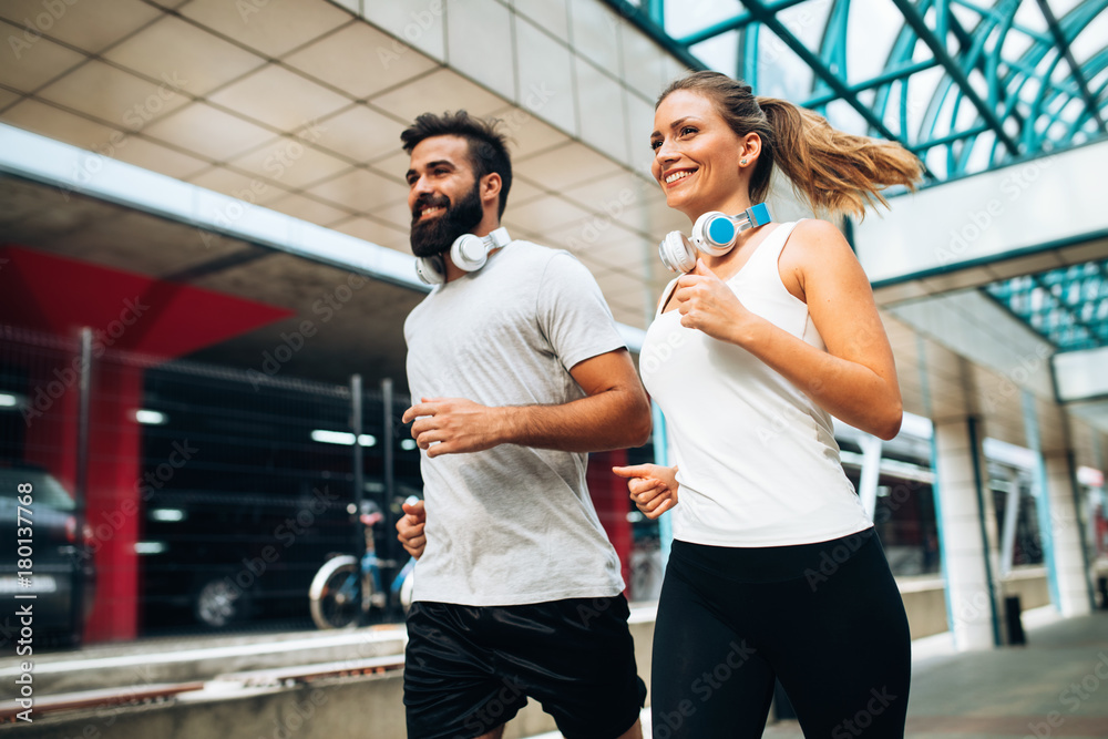 Young fitness couple running in urban area Young fitness couple running in urban area