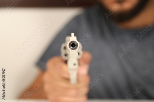 A Gun Looking into Screen Holding by a Bearded Man
