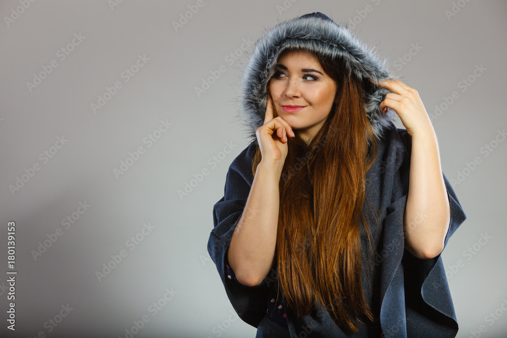 Happy woman wearing dark poncho with hood Happy woman wearing dark poncho with hood