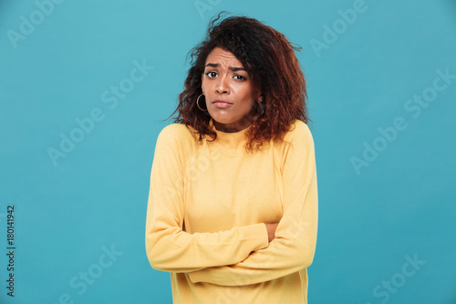Confused young african lady dressed in warm sweater